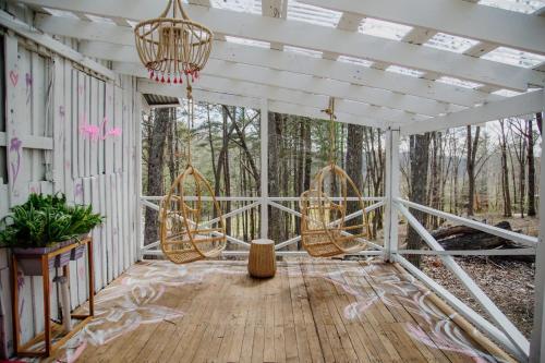 a screened in porch with a chandelier and chairs at Camp Swann in Tracy City