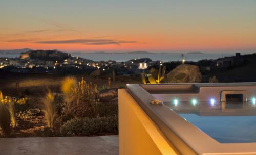 a view of a villa with a swimming pool at sunset at Opuntia Suites in Naxos Chora