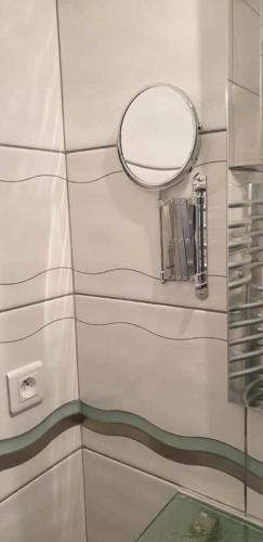 - un miroir rond sur un mur dans la salle de bains dans l'établissement Plaisirs de Lège, à Lège-Cap-Ferret