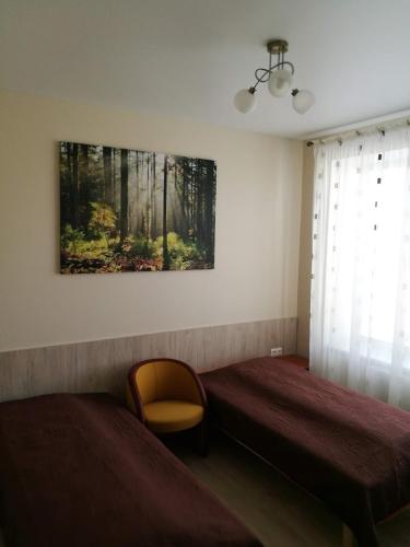 ein Schlafzimmer mit 2 Betten und einem Wandgemälde in der Unterkunft MUSKATAS in Rietavas