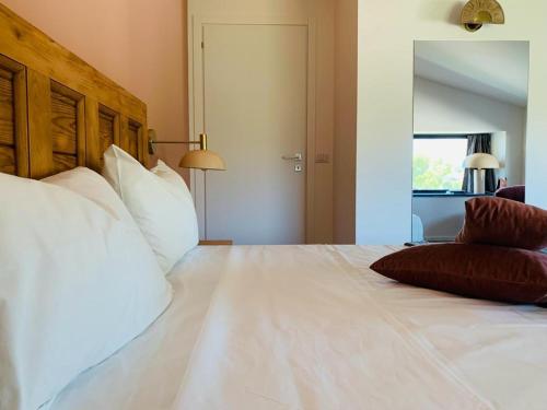 a bedroom with a large white bed with white pillows at PetraSicula Apartment in Acitrezza
