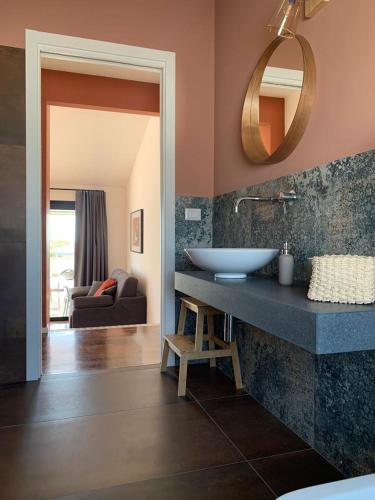a bathroom with a sink and a mirror on a counter at PetraSicula Apartment in Acitrezza