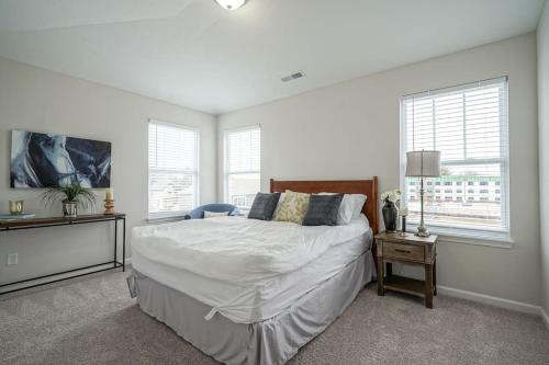 a bedroom with a large bed and two windows at DreamPlace Bana Home in Indianapolis