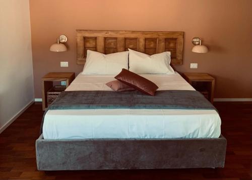 a bedroom with a large bed with two lamps at PetraSicula Apartment in Acitrezza