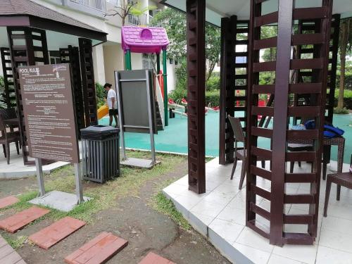 een restaurant met stoelen en een bord naast een zwembad bij South Residences in Manilla