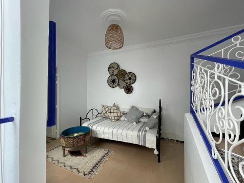 een slaapkamer met een bed in een witte kamer bij Dar Azam in Essaouira