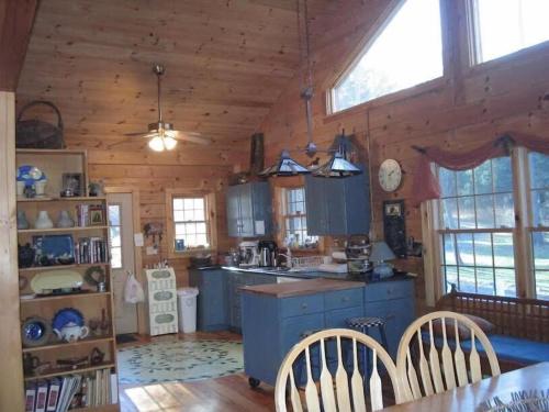 una cocina con armarios azules en una cabaña de madera en Charming, Quiet, Modern, River Front, en Hillsdale