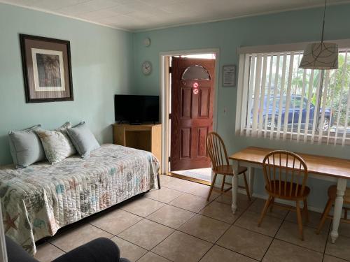 a bedroom with a bed and a desk and a table with chairs at Carousel Motel -Redington Shores in Redington Shores