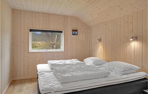 a bedroom with a bed with white sheets and a window at Pet Friendly Home In lbk With Sauna in Ålbæk