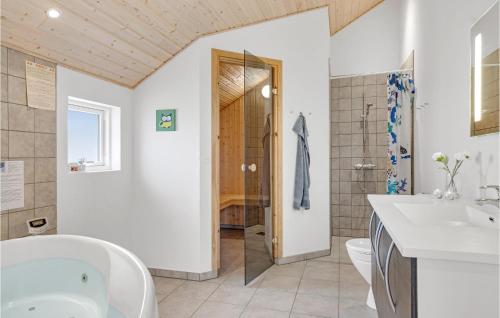 a bathroom with a tub and a toilet and a sink at Pet Friendly Home In lbk With Sauna in Ålbæk