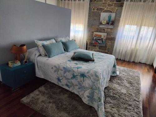 1 dormitorio con 1 cama con almohadas azules en Villa Carmen en András
