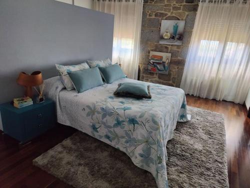 1 dormitorio con 1 cama con almohadas azules en Villa Carmen, en András