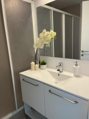 a bathroom with a sink with a mirror and flowers at Studio G712 Blaxy in Olimp