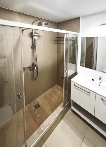 La salle de bains est pourvue d'une douche et d'un lavabo. dans l'établissement Studio G712 Blaxy, à Olimp