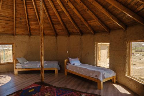 two beds in a room with two windows at Altyn Oimok Yurt Camp in Tong