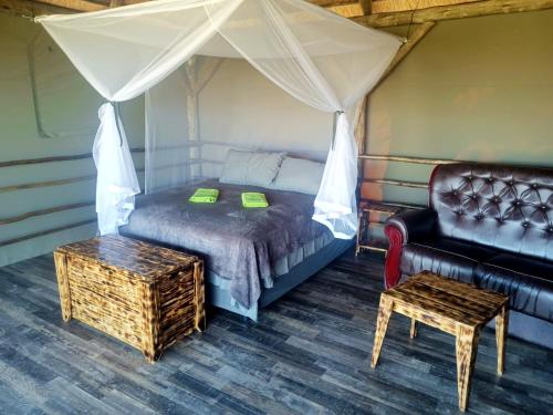 a bedroom with a bed and a couch and a table at Chobe Hideaway 