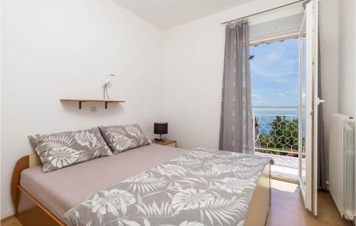 ein Schlafzimmer mit einem Bett und einem großen Fenster in der Unterkunft Lovely Apartment In Icici With Kitchen in Ičići