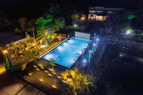 einen Blick über den Pool in der Nacht in der Unterkunft Rock Hut Tabor Hills Resort Vagamon in Vagamon