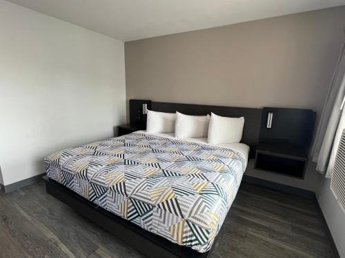 1 dormitorio con 1 cama con un edredón colorido en Motel 6-Ely, NV, en Ely