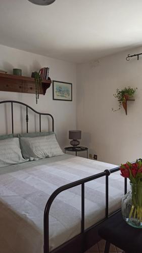 ein Schlafzimmer mit einem Bett und einer Vase aus Blumen auf einem Tisch in der Unterkunft Pia's Home in pieno centro storico in Palermo