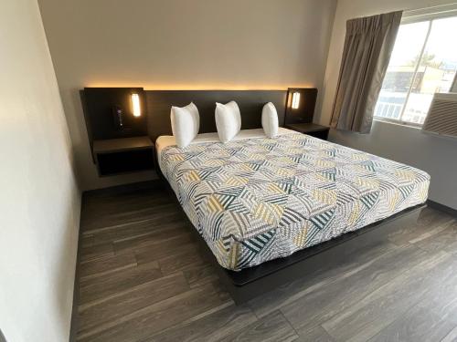 a bedroom with a bed with pillows on it at Motel 6-Ely, NV in Ely