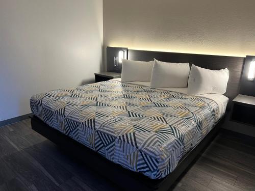 a hotel room with a bed with white pillows at Motel 6-Ely, NV in Ely