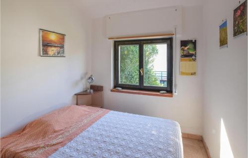 een slaapkamer met een bed en een raam bij 2 Bedroom Cozy Home In Roseto Capo Spulico in Roseto Capo Spulico