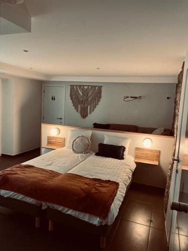 a bedroom with a large bed and two night stands at La Bel échappée in Aubel