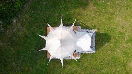 an overhead view of a white umbrella in the grass at Glamping Gozdna Jasa in Bovec