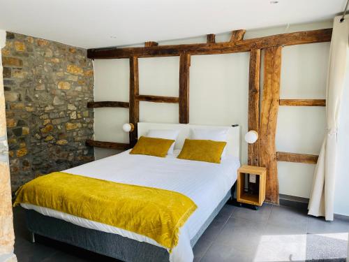 1 dormitorio con 1 cama blanca grande con sábanas amarillas en La Bel échappée, en Aubel