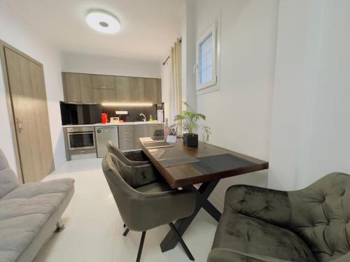 a living room with a wooden table and two chairs at Nikos Apartments Corfu in Agios Stefanos
