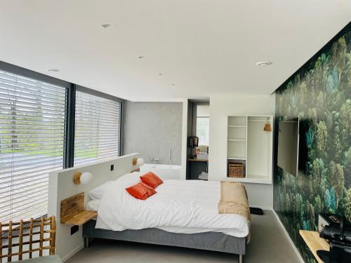a bedroom with a large bed and a large window at La Bel échappée in Aubel