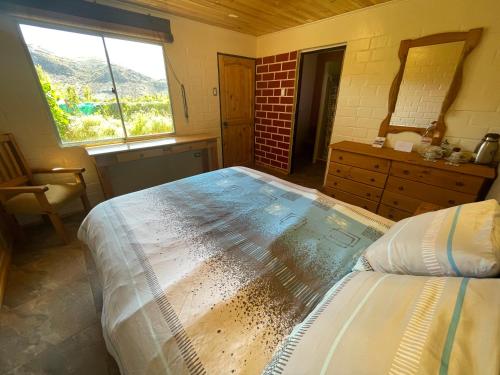 a bedroom with a large bed and a window at Cabalgatas y Alojamiento LocuraChile in Hurtado