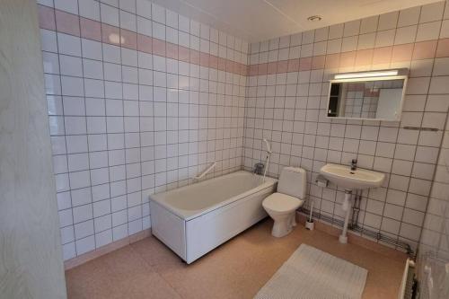 a bathroom with a tub and a toilet and a sink at Trivsamt parhus i lugnt område inne i Tranås! in Tranås