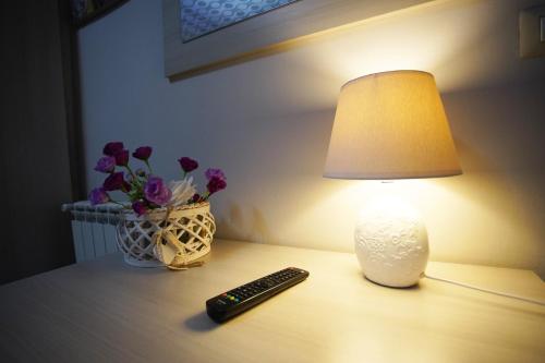 a table with a lamp and a remote control on it at Apartment Golden Dreams in Reggio Calabria