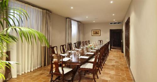 a long dining room with a long table and chairs at La Almoraima Hotel in Castellar de la Frontera