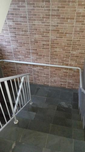 a staircase with a metal railing next to a brick wall at Edifício Master in Cascavel