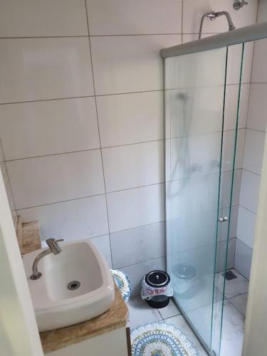 a bathroom with a sink and a glass shower at Hostel AJBJ Turismo in Curitiba