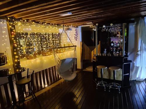 a bar with stools and lights on a wall at Hostel AJBJ Turismo in Curitiba