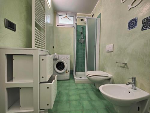 a bathroom with a toilet sink and a washing machine at GRADO APPARTAMENTO HUNGARIA in Grado