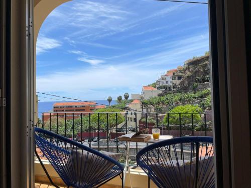 a view from a balcony with two chairs and a table at Vigário House in Câmara de Lobos