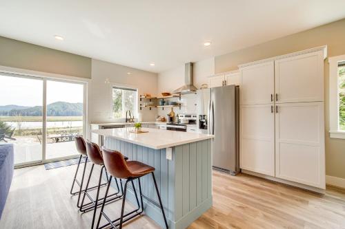 a kitchen with white cabinets and a counter with stools at Charming Florence Home with Fire Pit and River Views! in Florence