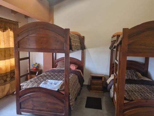 2 Etagenbetten in einem kleinen Zimmer mit einem Bett in der Unterkunft Hospedaje San Fernando in Cayambe