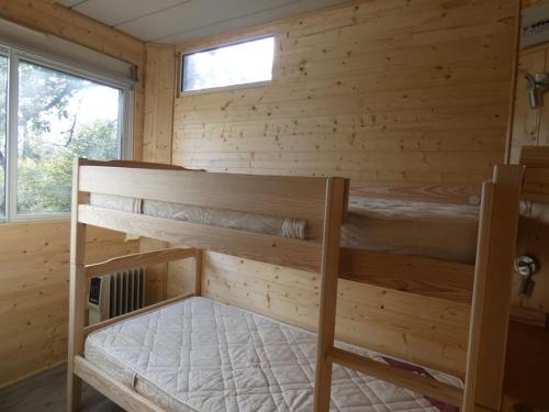 a bedroom with two bunk beds in a log cabin at Chalet avec terrasse face aux Pyrénées in Bartrés