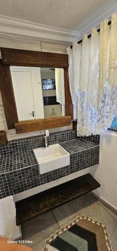 a bathroom with a sink and a mirror at Hostel AJBJ Turismo in Curitiba
