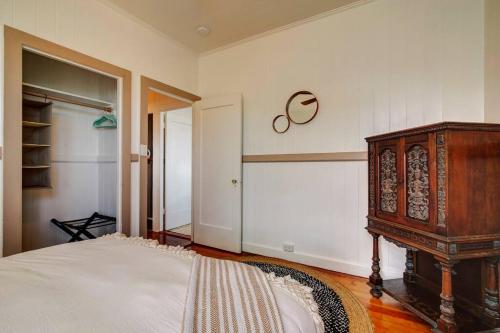 a bedroom with a bed and a wooden cabinet at NEW Paddler's Inn- 3BR Hilo Downtown in Hilo