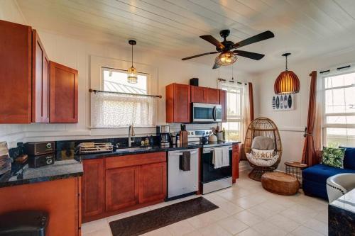 a kitchen with wooden cabinets and a ceiling fan at NEW Paddler's Inn- 3BR Hilo Downtown in Hilo