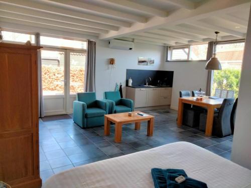 a living room with a couch and chairs and a tv at B&B Veers Buuten in Veere