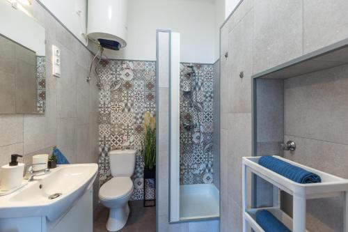 ein Bad mit einem Waschbecken, einem WC und einer Dusche in der Unterkunft ALLEE BUDA Apartment in Budapest