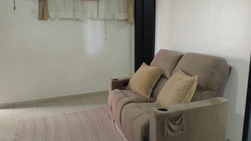 a couch in a living room with pillows on it at Edifício Master in Cascavel